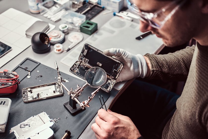 Technician testing a phone screen before packing