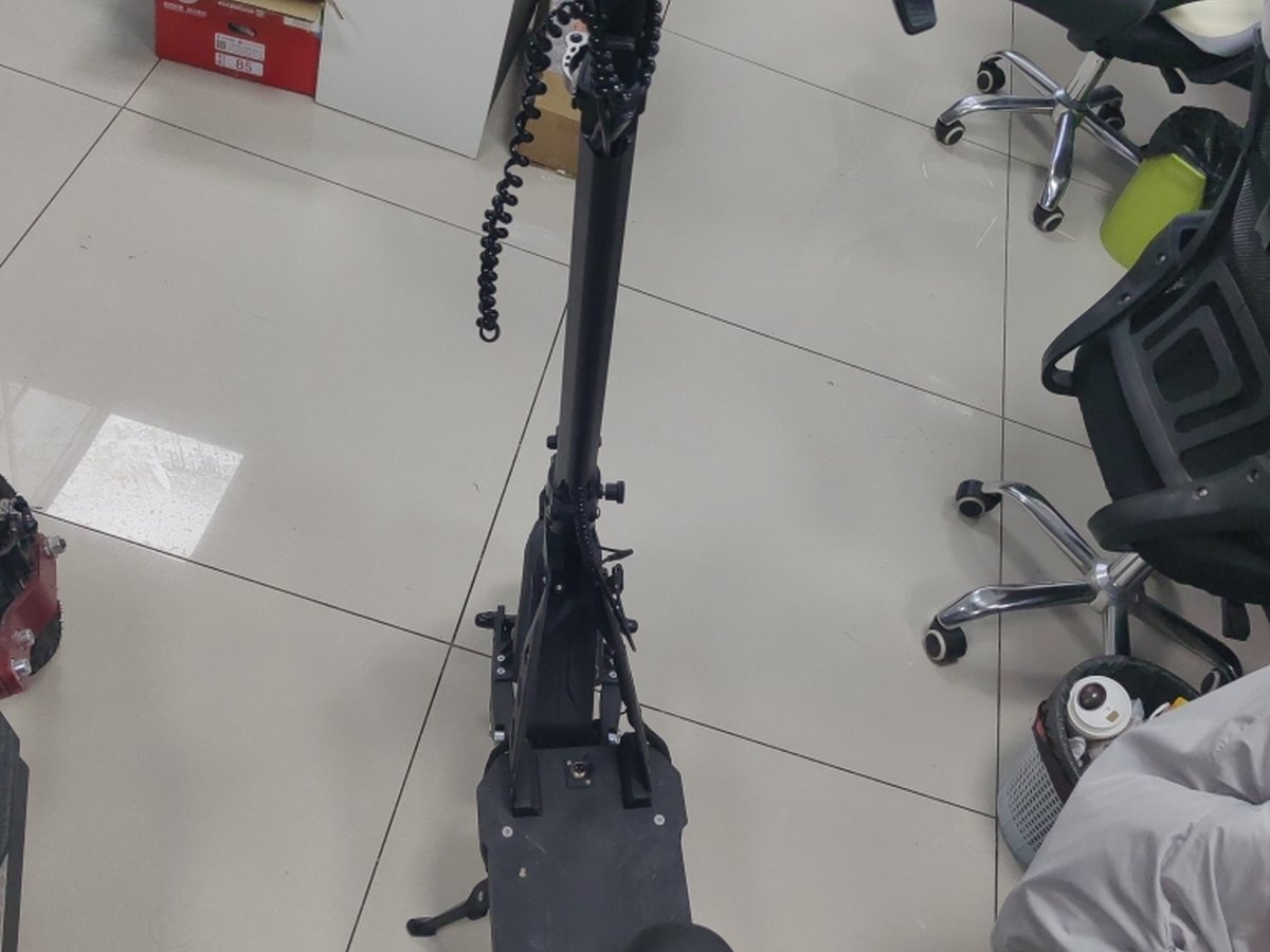 Top-down view of an electric scooter deck, seat, kickstand and folding stem