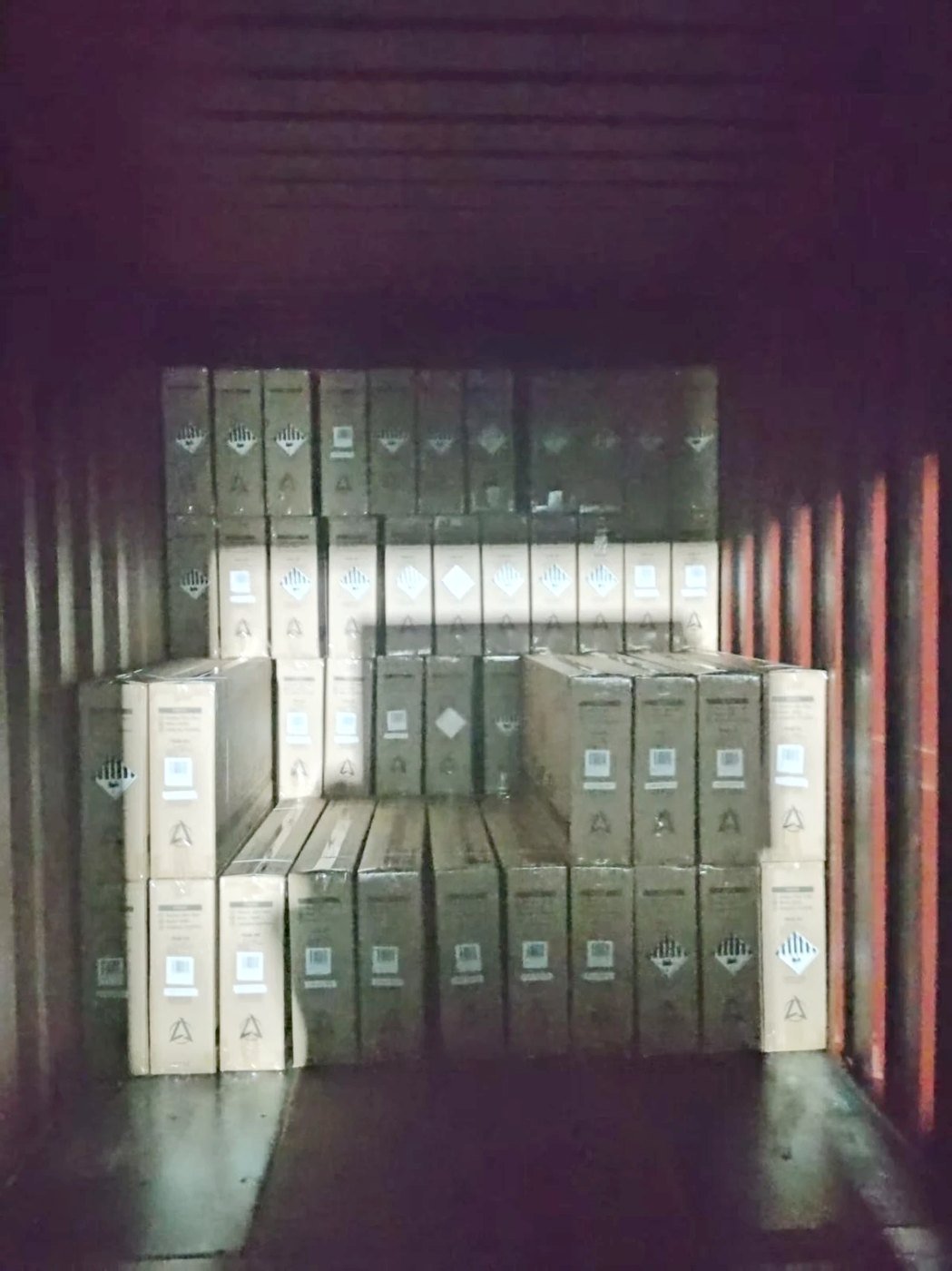 Cartons stacked inside a shipping container, each showing the Class 9A lithium battery hazard label