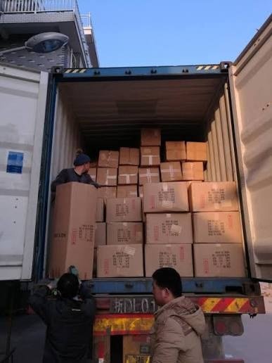 Warehouse crew loading cartons into an export container